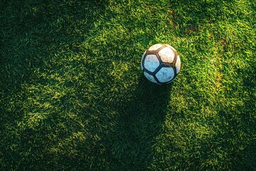 Top view of a soccer ball on lush green field