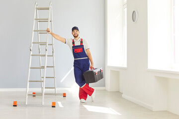 Portrait of a happy man working as a repairman or construction worker, standing with a ladder and instrument. Renovation highlights positive attitude and expertise in home improvement tasks.