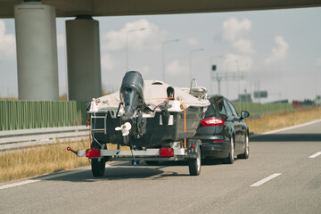 Car towing boat trailer on open highway.