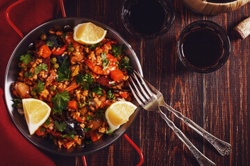 Paella with chicken, chorizo, seafood, vegetables and saffron served in the traditional pan.