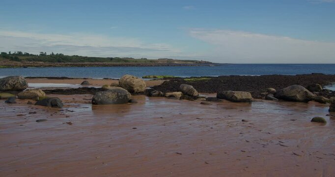 Extra wide shot of boulders and rocks exposed at low tide at Longhoughton beach of the howdiemony sands. Alnwick