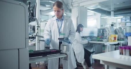Female Biochemist Conducts Research Experiments with New Medical Drug Products, Developing Modern Cure and Vaccines for Infectious Diseases. Team Working with Samples and Using Computers in a Lab