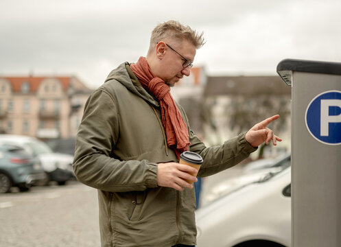 Man Uses Parking Meter In City Center