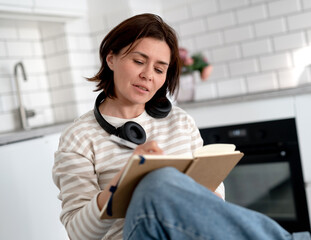 Young Woman Writes In Notebook At Home