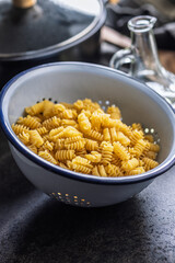 Uncooked italian pasta. Radiatori pasta in colander.
