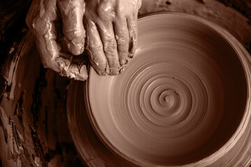 Potter shaping clay on the pottery wheel. New trending colour of the 2025 year 
