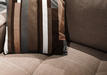 Multicolored pillow on yellow sofa background. New trending colour of the 2025 year 
