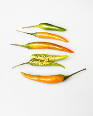 yellow red orange chili peppers lie on a white background
