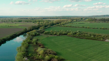 Breathtaking landscape from a height: the river meandering through the fields offers a unique view from a drone. Natural beauty and harmony of water and green spaces.