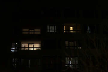 A large building featuring numerous windows is beautifully lit up at night