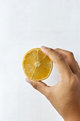 Hand Holding a Lemon with Studio Lighting on White Background