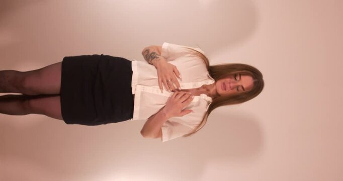 Beautiful girl with shirt open shirt covering her breasts and teasing with sexy movements. Vertical shot