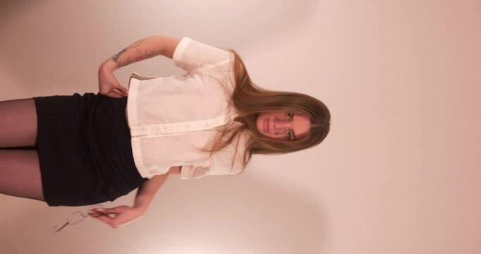 Beautiful sexy girl teasing and looking to the camera while she move sin a sexy way. Vertical shot