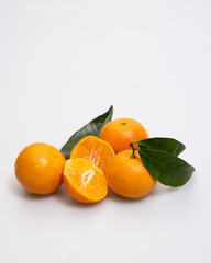 oranges and tangerines with leaves whole and in size lie on a white background