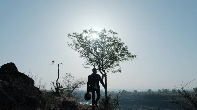 Young man walking in Suhel Diwan South Asian in sunny day and trees and rocks in the background