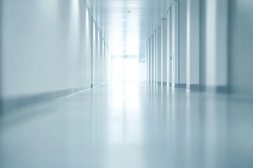 Blurred hospital hallway with blue lighting, reflective floor, and bright overhead lights