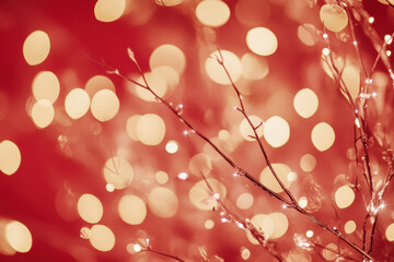 Festive bokeh lights with delicate twigs on a red background