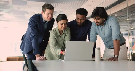 Group of four diverse office workers CEO managers looking at laptop screen, discussing a project. Busy professionals collaborate on business strategies, using tech solutions for teamwork and success - Powered by Adobe