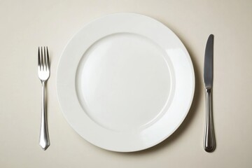 Simple white plate with fork and knife arranged for a meal setting