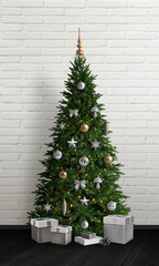 Christmas tree with white decorations and lights in front of a white brick wall, featuring white gifts at the base, perfect for festive promotions