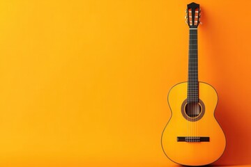 Fototapeta premium A classic acoustic guitar resting against a bright orange wall