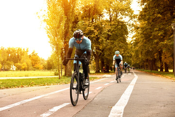 Group of athletic people riding bicycles outdoors