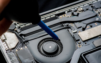 close up of Technician repairing electronic circuit board,Cleaning the Interior of a Laptop Computer