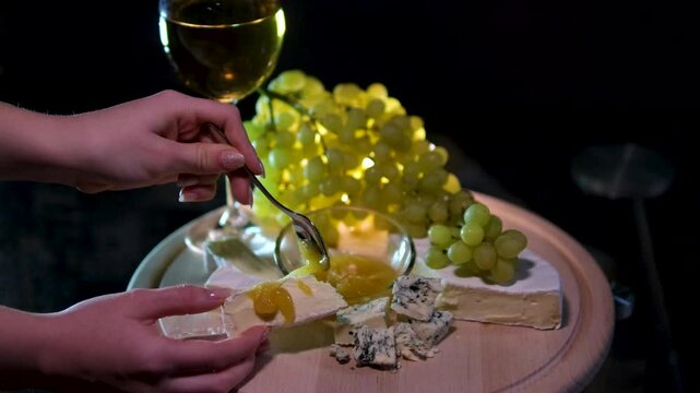 cheese white wine green grapes brie cheese with honey camera slowly moving black background. dorblu cheese