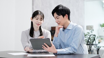 タブレットで資料を見る男女