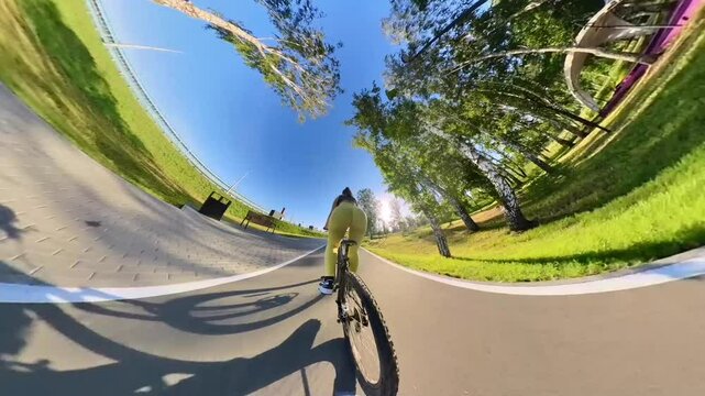 Rear view of a Caucasian woman with large buttocks riding a bicycle. Video 360. 