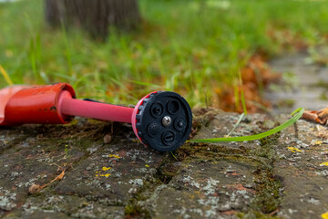 Lawn care tool on stone path surrounded by green grass in a peaceful garden setting