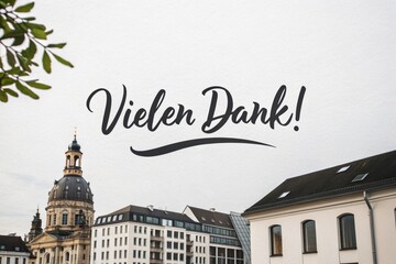 "Vielen Dank!" translates to "Thank you very much!" in English. The image features this text over a European cityscape with classic architecture, a cloudy sky, and leafy branches in the foreground.