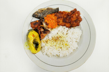 rice mixed with fried fish and tempeh vegetables on a white plate