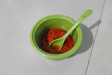 Stir-fried red chili sauce in a small bowl on the dining table