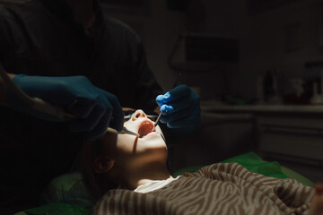 Cropped portrait of little girl with pigtails hair sitting in dental chair looking at camera. A...