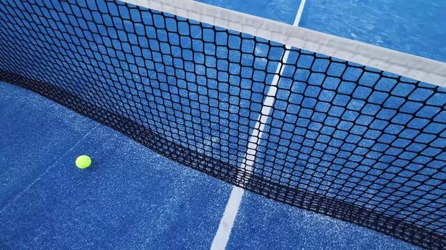 paddle tennis balls hitting the net of a paddle tennis court
