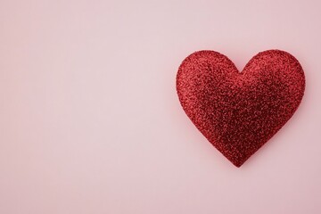 Obraz premium Glittering red heart decoration on a soft pink background for celebrations and events