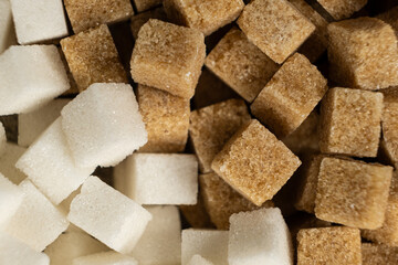 Cubes of unrefined brown demerara sugar and white refined beet sugar.