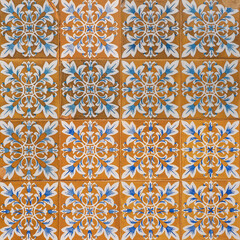 Fragment of building wall with colorful ceramic tiles. Azulejos, close up. Traditional ornate Portuguese architecture. Abstract background, textured ornate pattern for design or backdrop.
