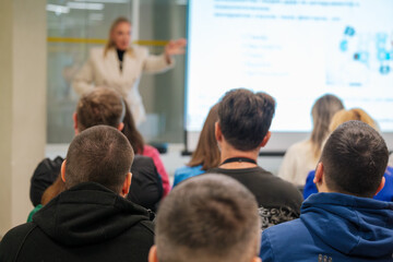 Audience attentively watching speaker during professional presentation in conference room. Focus on...