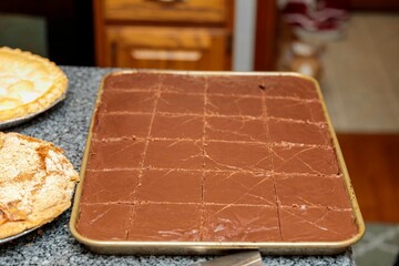 slicing the Thanksgiving Day Cowboy Cake made by a guest  to begin serving it
