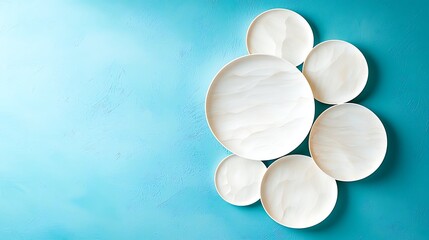 A series of perfectly round white circles gradually increase in size and overlap each other on a vibrant blue background, creating a visually captivating and dynamic composition.