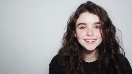 Fototapeta premium Smiling young woman with long curly hair, natural beauty, cheerful expression