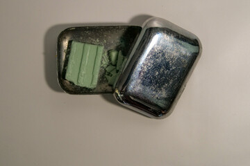 Antique vintage silver soap holder with soap inside and the lid open on a white background.