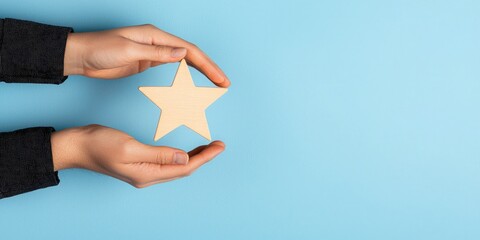Hands holding a five-pointed star, symbolizing aspiration and achievement against a blue background.