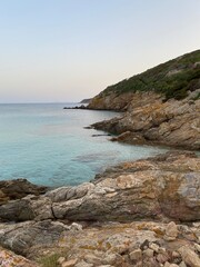 Rocky coastline with clear turquoise waters at dusk