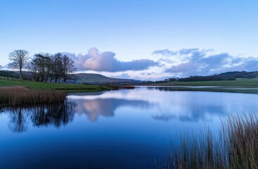 Obraz premium Tranquil Lake Reflecting Clouds and Trees at Dusk