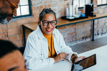 Mature black entrepreneur smiling with confidence in modern workspace, showcasing business...
