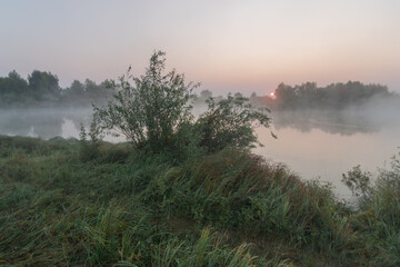 rising sun over foggy river