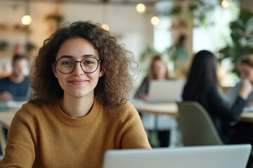 Smiling woman with glasses at laptop in busy cafe